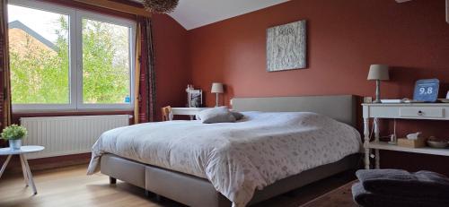 a bedroom with a large bed with red walls at Green Hill Guest Room Overijse in Overijse