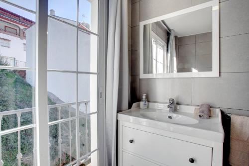 a bathroom with a sink and a mirror and a window at Alojamientos Monteverde in Ojén