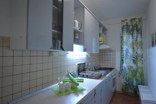 a kitchen with white cabinets and a counter top at Apartman Balen J. in Banjol