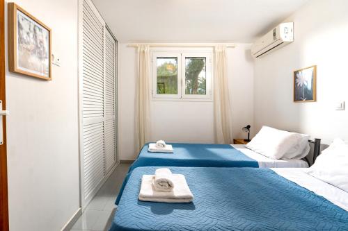 two beds in a small room with towels on them at Blue Bay Apartment in Gouvia