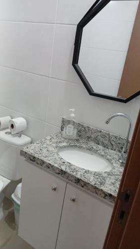 a bathroom with a sink and a mirror at Apartamento Cabedelo João Pessoa in Cabedelo