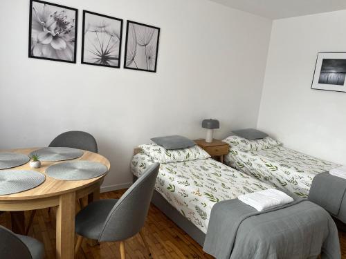 a bedroom with two beds and a table and chairs at Apartament Centrum Możliwość wystawiania Faktur- WI-FI in Suwałki