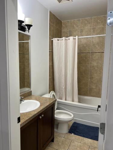 a bathroom with a toilet and a sink and a shower at 2 Bedroom plus den 2 Bathroom apartment in Surrey