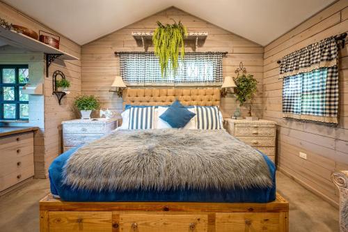a bedroom with a large bed in a room with wooden walls at The Tree Cabins Quinta Pavo Real by AcoModo in San José