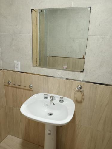 a white sink in a bathroom with a mirror at Residencia Los Miottis in Necochea