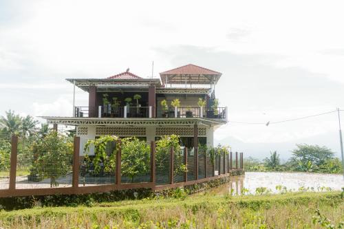 a house on the side of a body of water at Omah Ulin in Bandongan