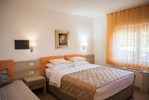 a bedroom with a large bed and a window at Hotel Pervan in Međugorje