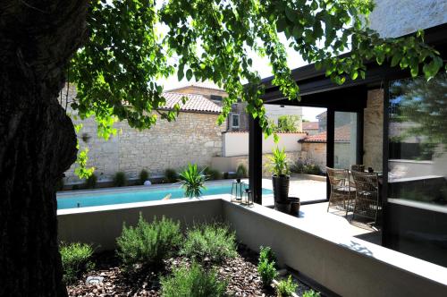 a backyard with a swimming pool and a house at Villa Angelina - design stone house in Markovac in Višnjan