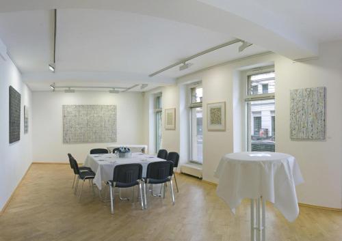 a room with a table and chairs in it at Galerie Hotel Leipziger Hof in Leipzig