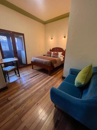 a bedroom with a bed and a couch and a table at Terra Sagrada Cusco in Cusco