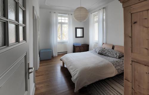 a white bedroom with a bed and a window at Jugendstil Ferienwohnung Neustadt in Neustadt an der Weinstraße