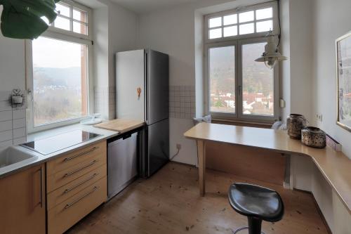 a kitchen with a refrigerator and a chair in it at Jugendstil Ferienwohnung Neustadt in Neustadt an der Weinstraße