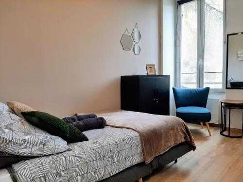 a bedroom with a bed and a blue chair at Les Apparts de Marmande - Petit Cocon en ville in Marmande