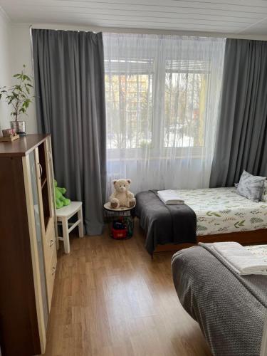 a bedroom with two beds and a window with a teddy bear at Apartament Korczaka możliwość wystawiania Faktur, WI-FI in Suwałki