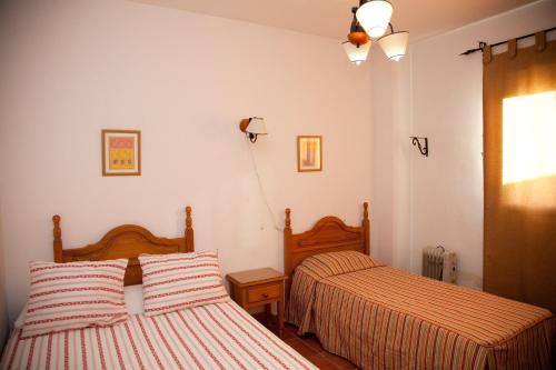 カスティブランコ・デ・ロス・アロヨスにあるCaserío de Vazquez 2のベッドルーム(ベッド2台、ランプ付)