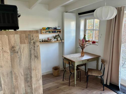 a dining room with a table and a window at De Sleeuwijkerwaard in Sleeuwijk