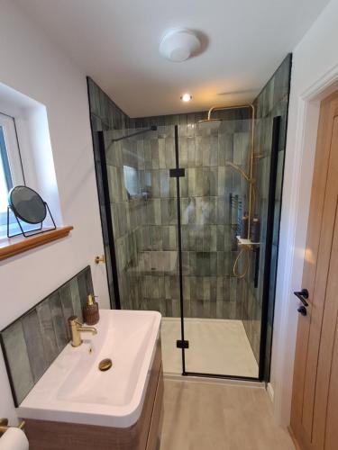 a bathroom with a shower and a white sink at An Sealladh in Fort William