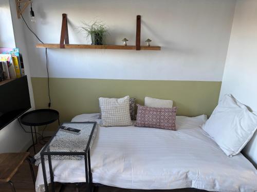 a bed with pillows and a table in a room at De Sleeuwijkerwaard in Sleeuwijk