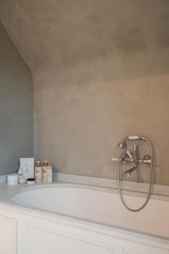 a bath tub with a shower in a bathroom at Villa Ultima Thule in Ostend