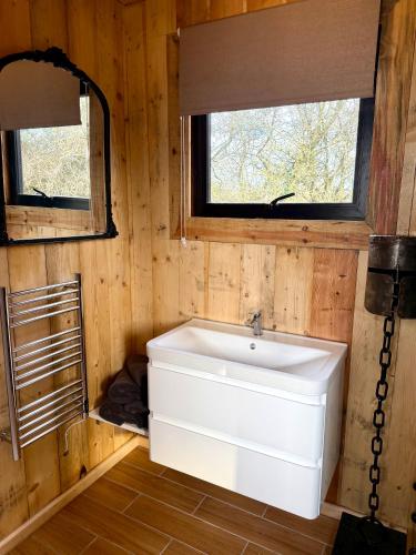 a bathroom with a white sink and two windows at Willow Court Farm, The Copper Castle & Petting Farm, 8 min to Legoland & Windsor, 15 min to Lapland UK in Windsor