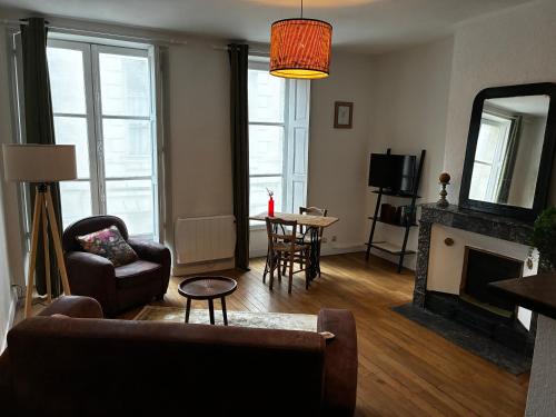 Chez hortense في بلوا: غرفة معيشة بها أريكة ومدفأة