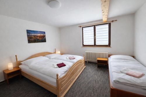 two twin beds in a room with a window at Prášily 100 - apartmány in Prášily