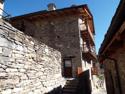 an old stone building with stairs and a door at Nebin - casa vacanze Valle Maira in Stroppo