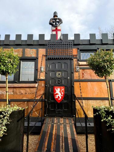a black door with a red shield on it at Willow Court Farm, The Copper Castle & Petting Farm, 8 min to Legoland & Windsor, 15 min to Lapland UK in Windsor