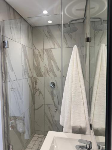 a bathroom with a shower and a sink with towels at Unit 4913 - Ellipse Waterfall in Midrand