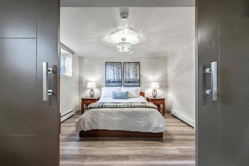 a bedroom with a bed and two tables and a window at Bright & Cozy Central Retreat in Calgary