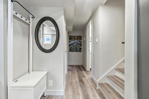 a hallway with a mirror and stairs in a house at Bright & Cozy Central Retreat in Calgary