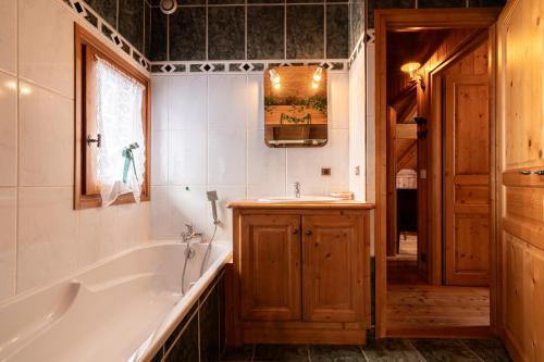 a bathroom with a tub and a sink at Chalet Savoyard in La Clusaz