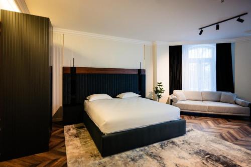 a bedroom with a bed and a couch at Ghica Boutique Suites in Vaslui