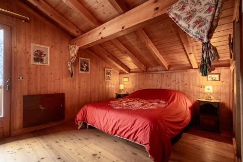 a bedroom with a bed in a wooden house at Chalet Savoyard in La Clusaz