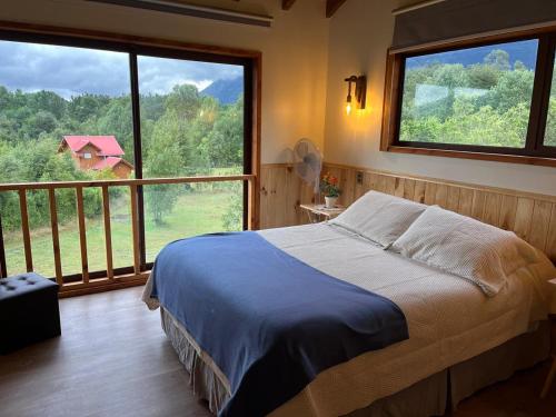 a bedroom with a bed and a large window at Cabaña Caburgua vista al Volcán, Senderos del Bosque in Pucón