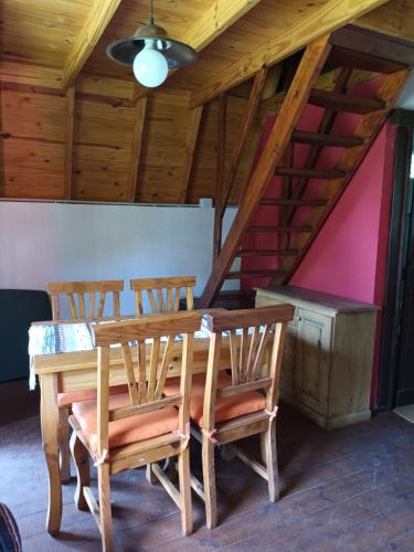 a dining room table with four chairs and a ceiling at Cabañas El Tala in Villa la Bolsa