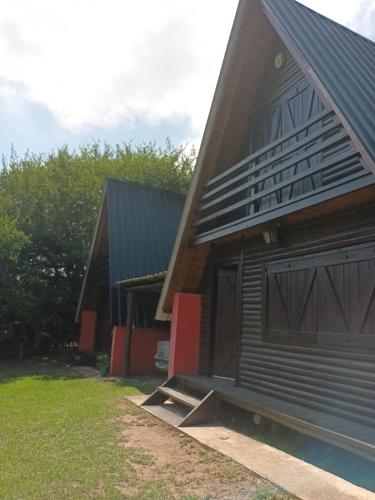 a house with a garage and a building at Cabañas El Tala in Villa la Bolsa