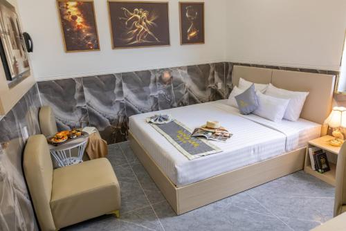 a small bedroom with a bed and a chair at Nghia Lan Maison - DL Center in Da Lat