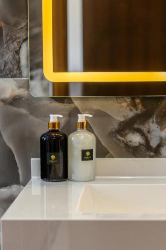 two bottles of soap sitting on a white sink at Nghia Lan Maison - DL Center in Da Lat