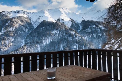 a wooden table with a glass on top of a mountain at Family-friendly apartement in Lumbrein