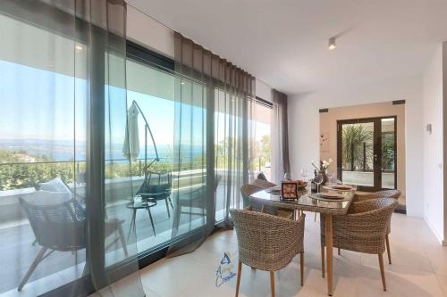 a dining room with a table and chairs and a large window at Villa Bella Vista 2 in Ičići