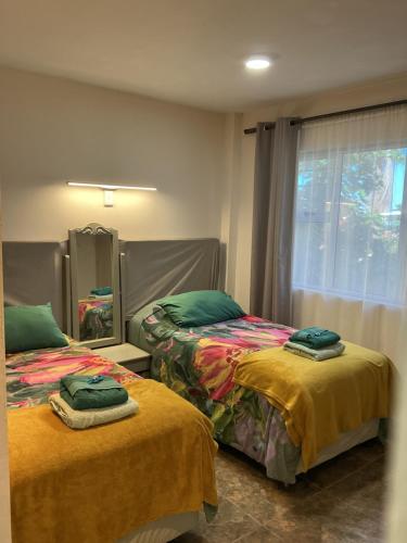 a bedroom with two beds and a window at Mispa George in George