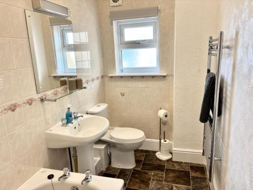 a white bathroom with a sink and a toilet at Ocean View in Ilfracombe