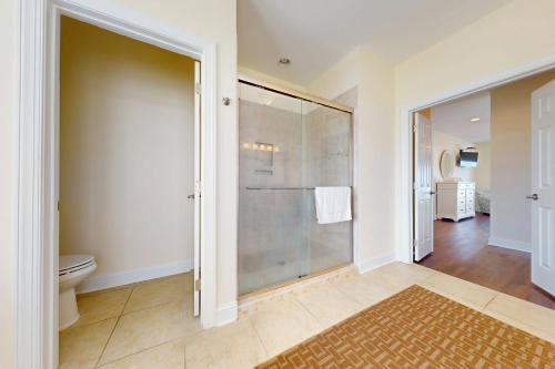 a bathroom with a toilet and a glass shower at NTB106 Scotch Bonnet Sunrise in North Topsail Beach