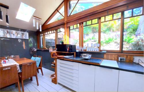 a kitchen with a counter and a table and some windows at PALMIE Gold in Palm Beach