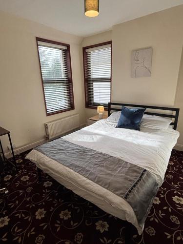 a bedroom with a bed with a blue pillow on it at Amazing Entire Home in WOLVERHAMPTON in Wolverhampton