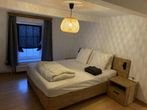 a bedroom with a bed with a black bag on it at Le Cat'saisons in Wellin