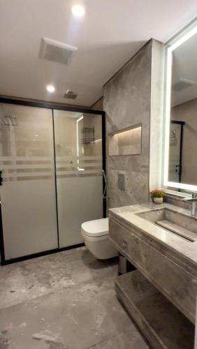 a bathroom with a toilet and a sink and a mirror at AINOSAH Residences in Medina