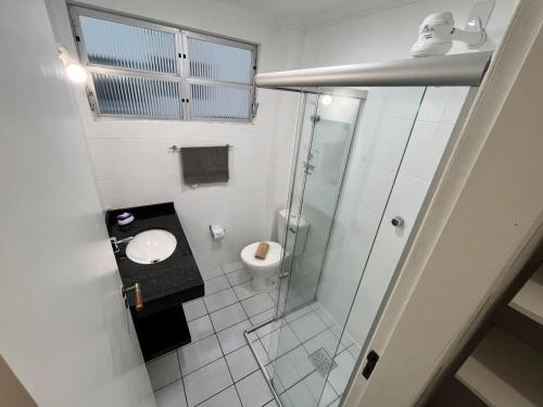 a bathroom with a glass shower and a toilet at Residencial Larissa Elena in Florianópolis