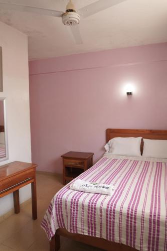 a bedroom with a bed with a striped blanket at Hotel Reforma in Veracruz